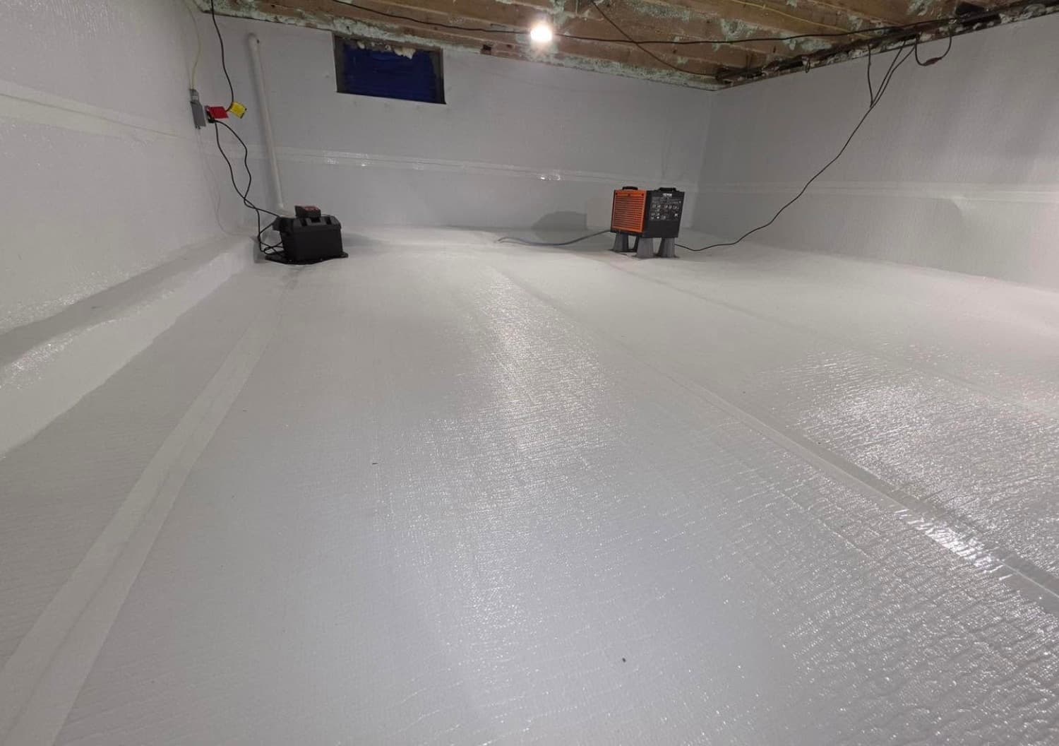 Encapsulated crawl space with a sump pump, battery backup, and dehumidifier tied into the drainage system